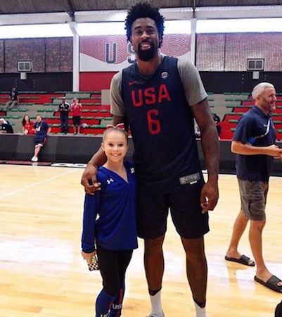 US Olympic gymnast standing beside an Olympic basketball player.