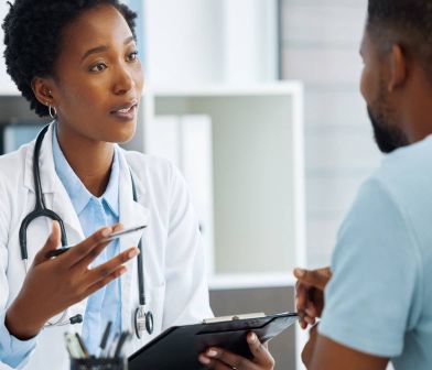 A photograph of a doctor speaking with a patient.